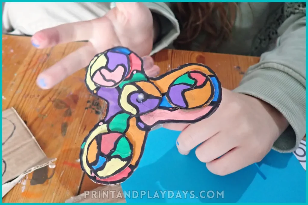 child with a cardboard fidget spinner