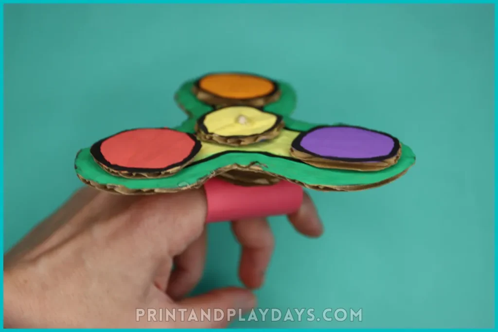 cardboard fidget spinner on a ring made out of paper